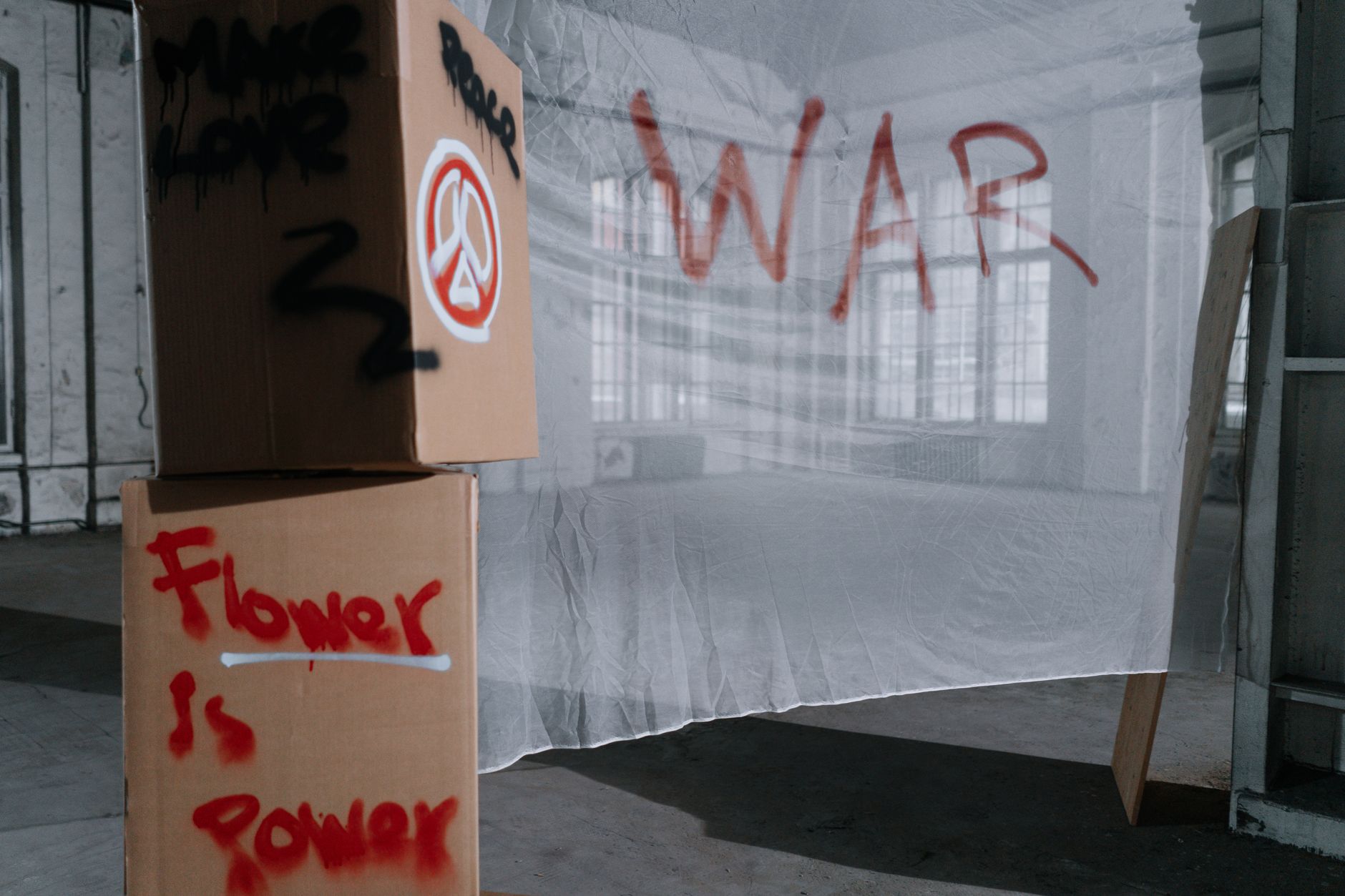 Cardboard boxes with peace and anti-war slogans in a protest setting.