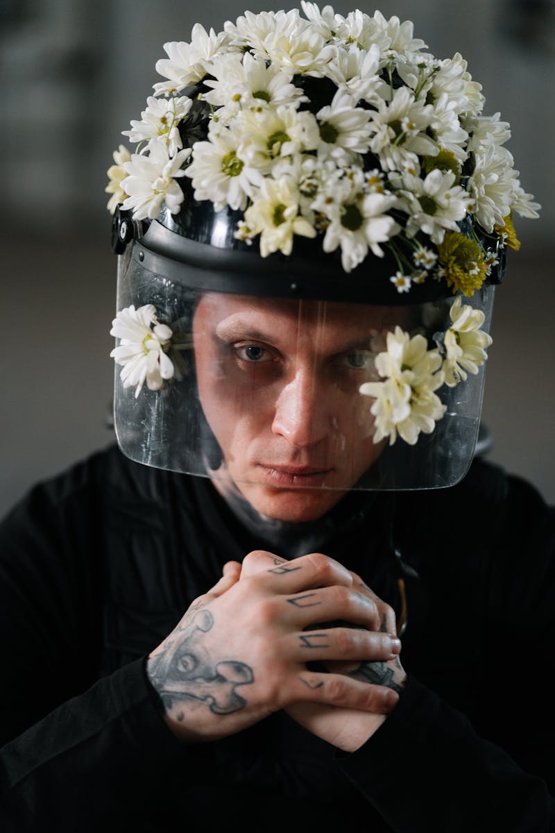 A young man wearing a helmet decorated with flowers, symbolizing peaceful protest.