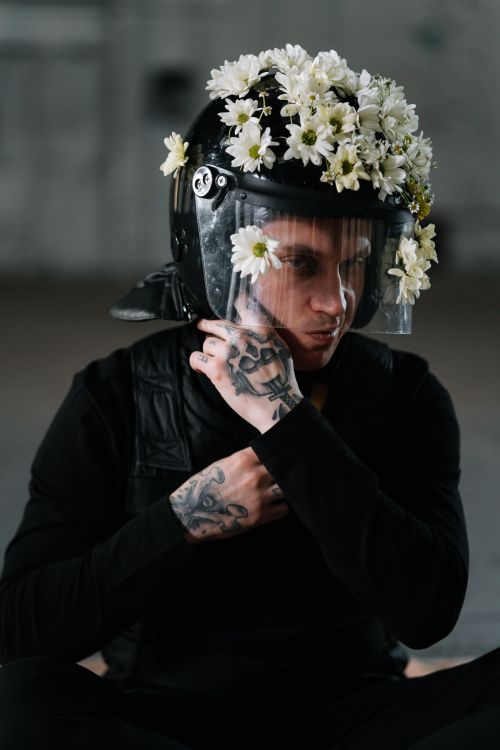 Free A contemplative protester adorned with floral helmet symbolizing peace in activism. Stock Photo