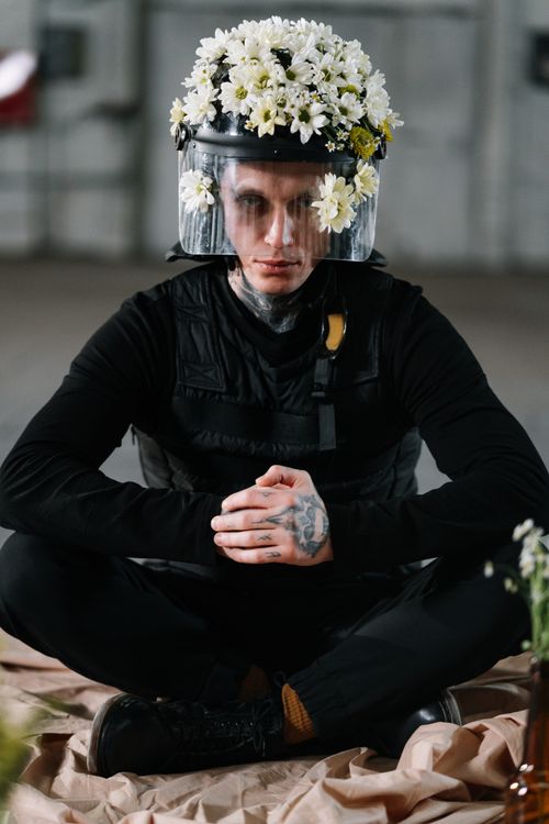 Free A serene image of a protester with a helmet adorned with flowers, symbolizing peaceful activism. Stock Photo