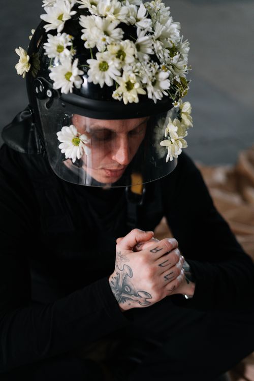 Free A protester wearing a helmet adorned with flowers embodying nonviolence and pacifism. Stock Photo