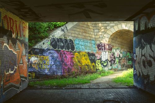 Free Colorful graffiti art adorns the walls of a stone tunnel in Brno, Czechia. Stock Photo