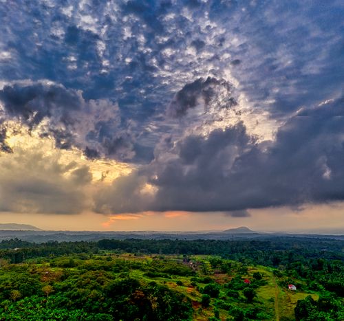 Free Aerial view of lush countryside with dramatic clouds during sunset in Banten, Indonesia. Stock Photo
