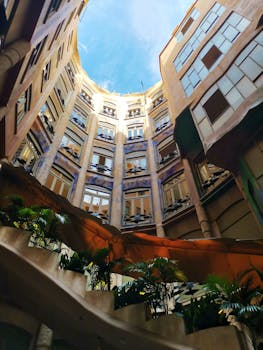Stunning view of Casa Milà's spiraling internal courtyard with vibrant plants.