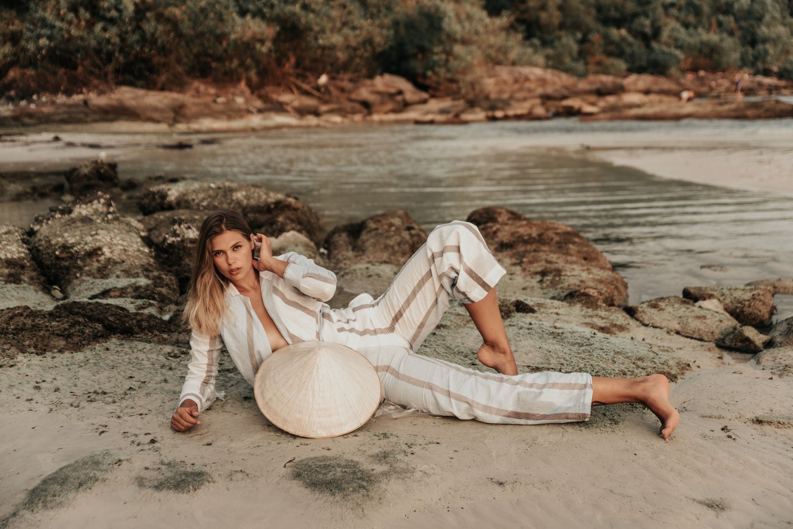 A woman in a soft neutral striped outfit, sun-washed and tonal