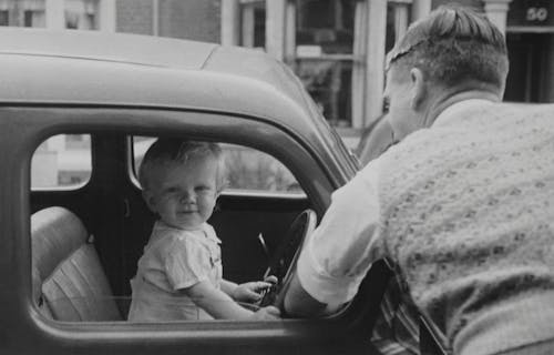 Free Man Looking At His Son Inside A Classic Car Stock Photo