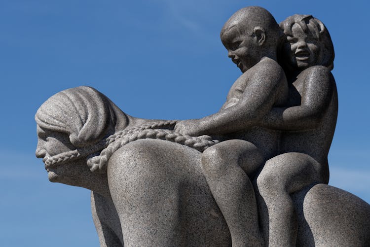 Classical Stone Sculpture Of Children Riding On Womans Back