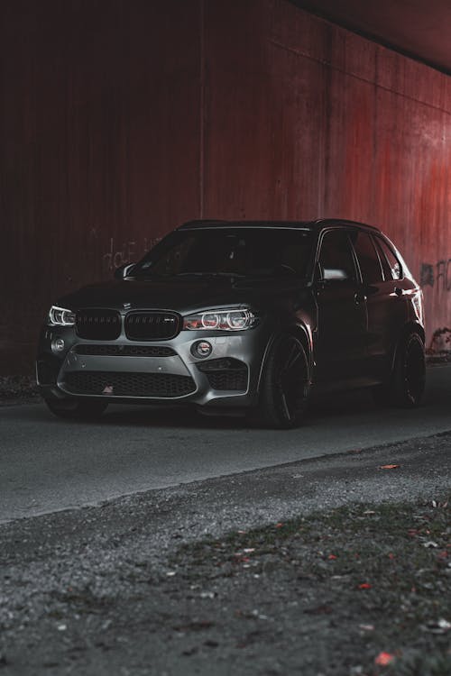 A Gray BMW X5 Parked by a Red Wall