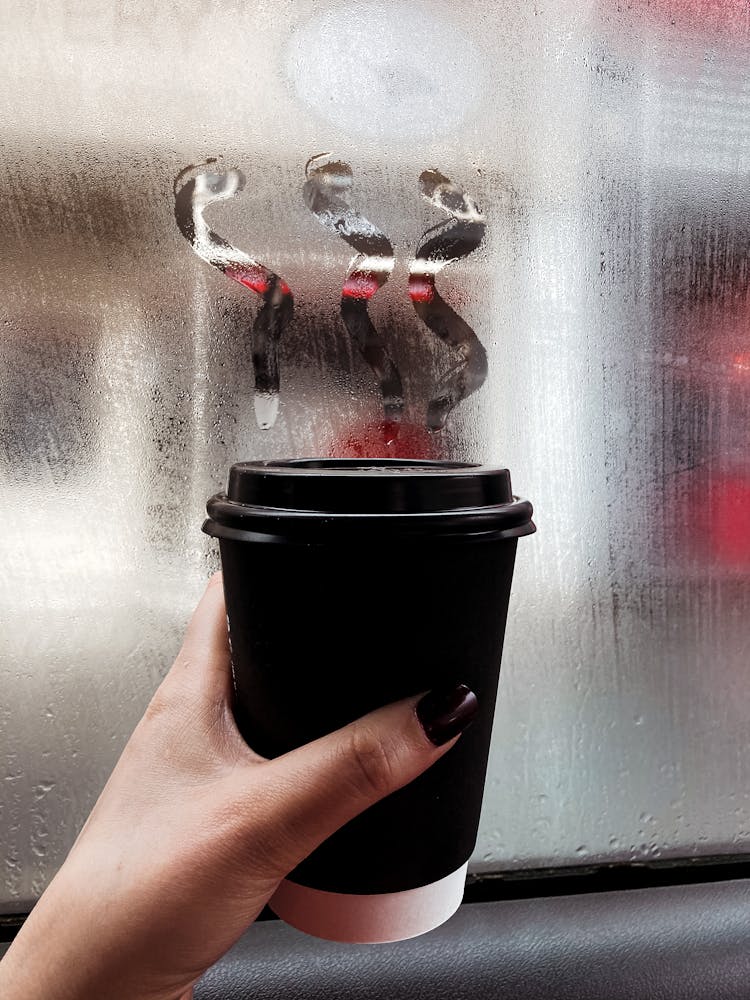 Hand Woman Holding Cup Of Takeaway Coffee Near Misted Window