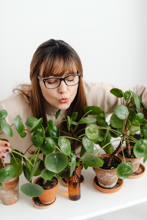 Free A Woman Wearing Eyeglasses Near the Potted Plants on White Table Stock Photo