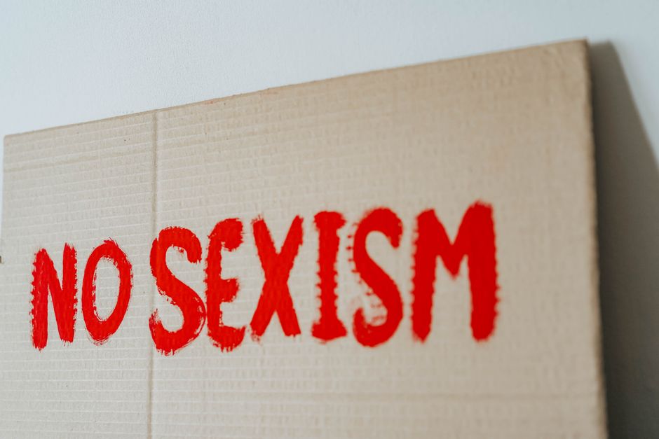 Cartel de cartón con el texto 'NO AL SEXISMO' pintado en letras rojas en negrita para la igualdad de género.