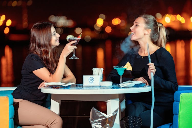 Two Women Drinking And Smoking Shisha