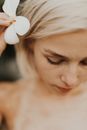 A Woman Putting a Flower on Her Ear