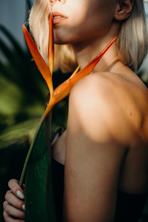 A Woman Holding an Orange Flower