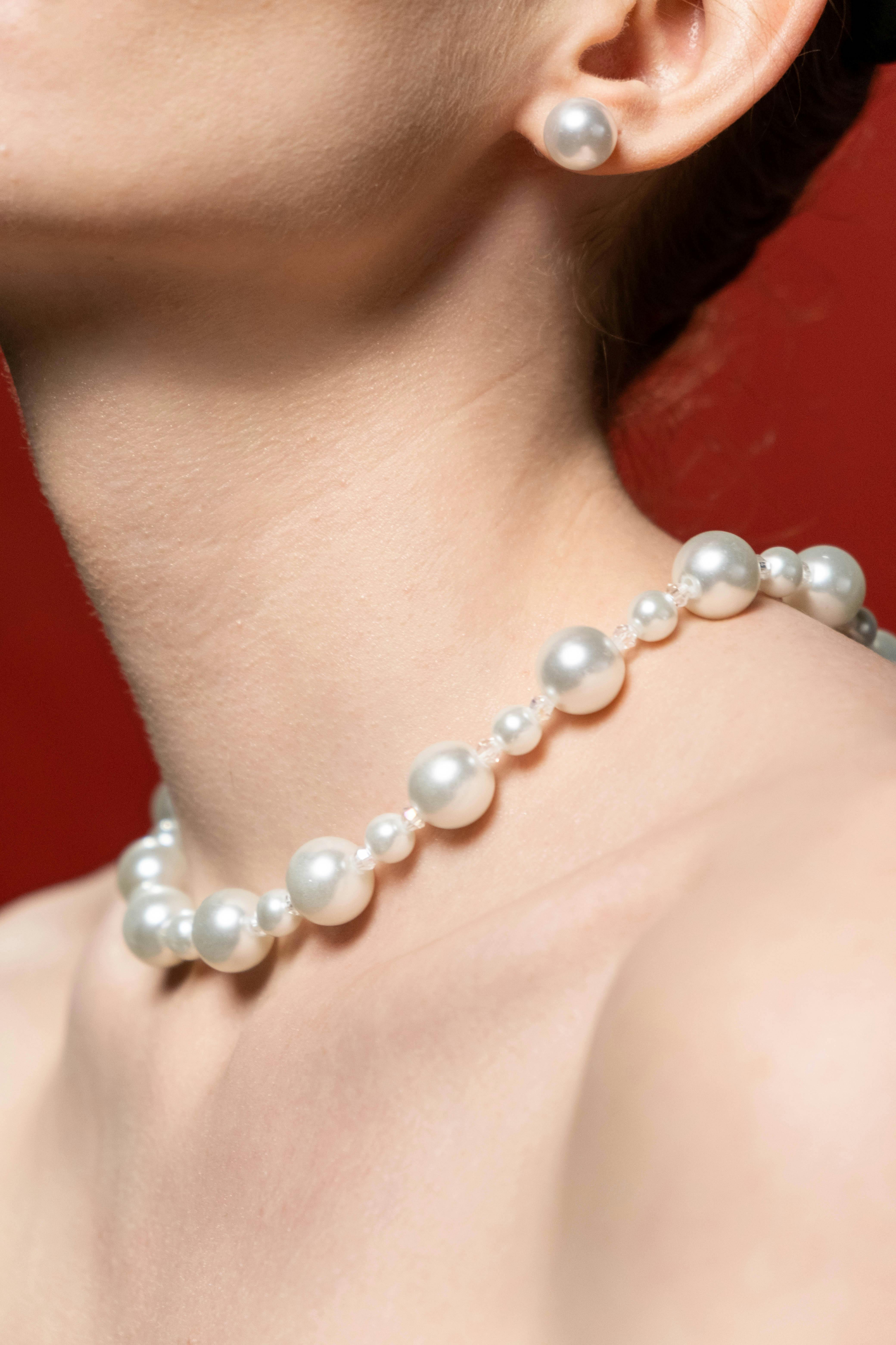 a person wearing white pearl necklace