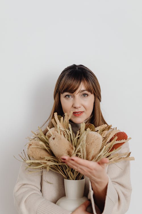 Free Woman Holding a Beautiful Autumnal Flower Arrangement in a Vase Stock Photo