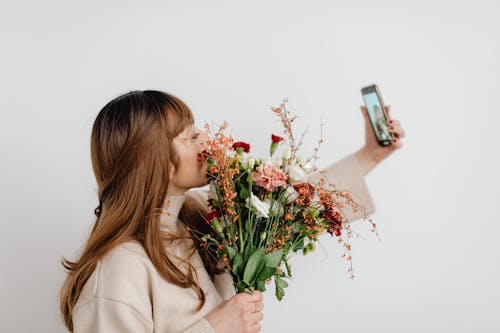 Kostenloses Stock Foto zu blumen, braune haare, festhalten