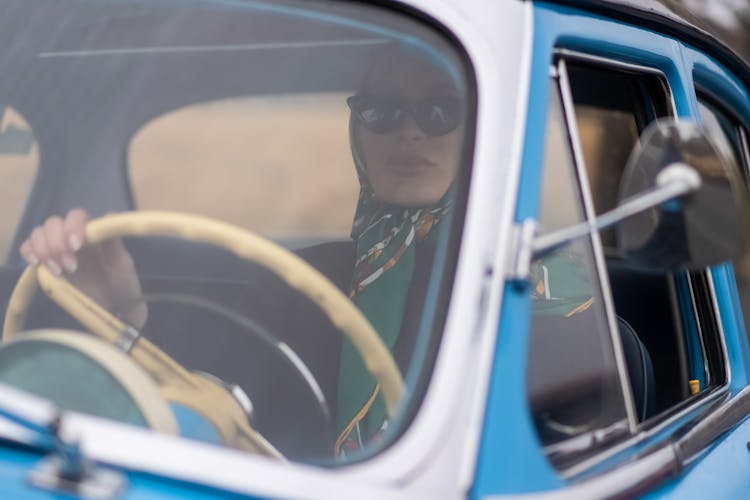 Serious Stylish Woman Driving Vintage Car