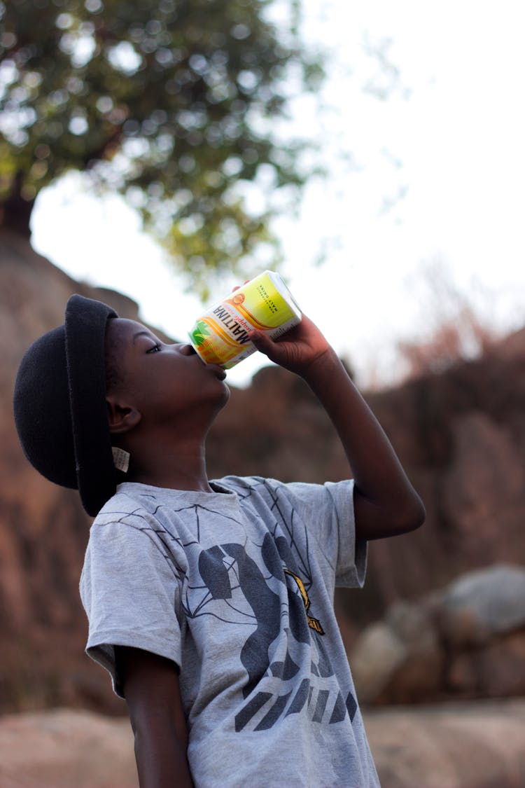 A Kid Drinking From A Can