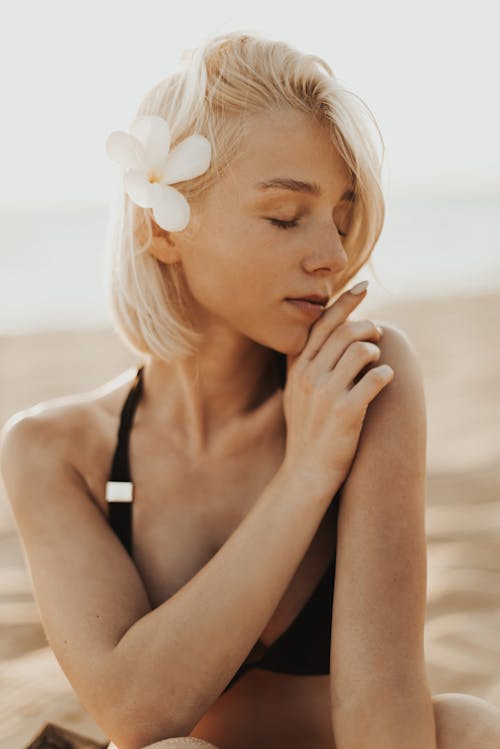 Woman in Black Swimwear with Flower on Her Ear