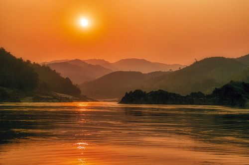 Free Serene sunset landscape over the Mekong River with scenic mountains in Bokeo Province, Laos. Stock Photo