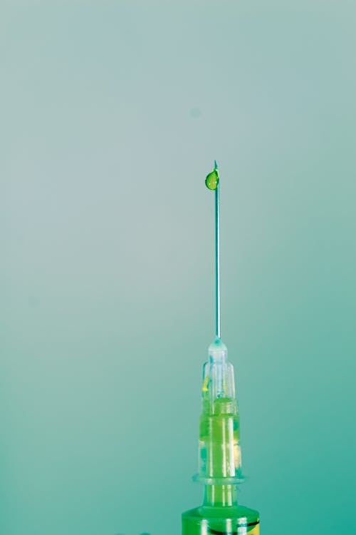 Close-up of Green Liquid Coming Out of a Needle of a Syringe 