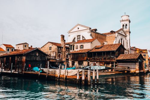 Free Charming canal-side view of rustic buildings and gondolas in Venice, Italy. Stock Photo
