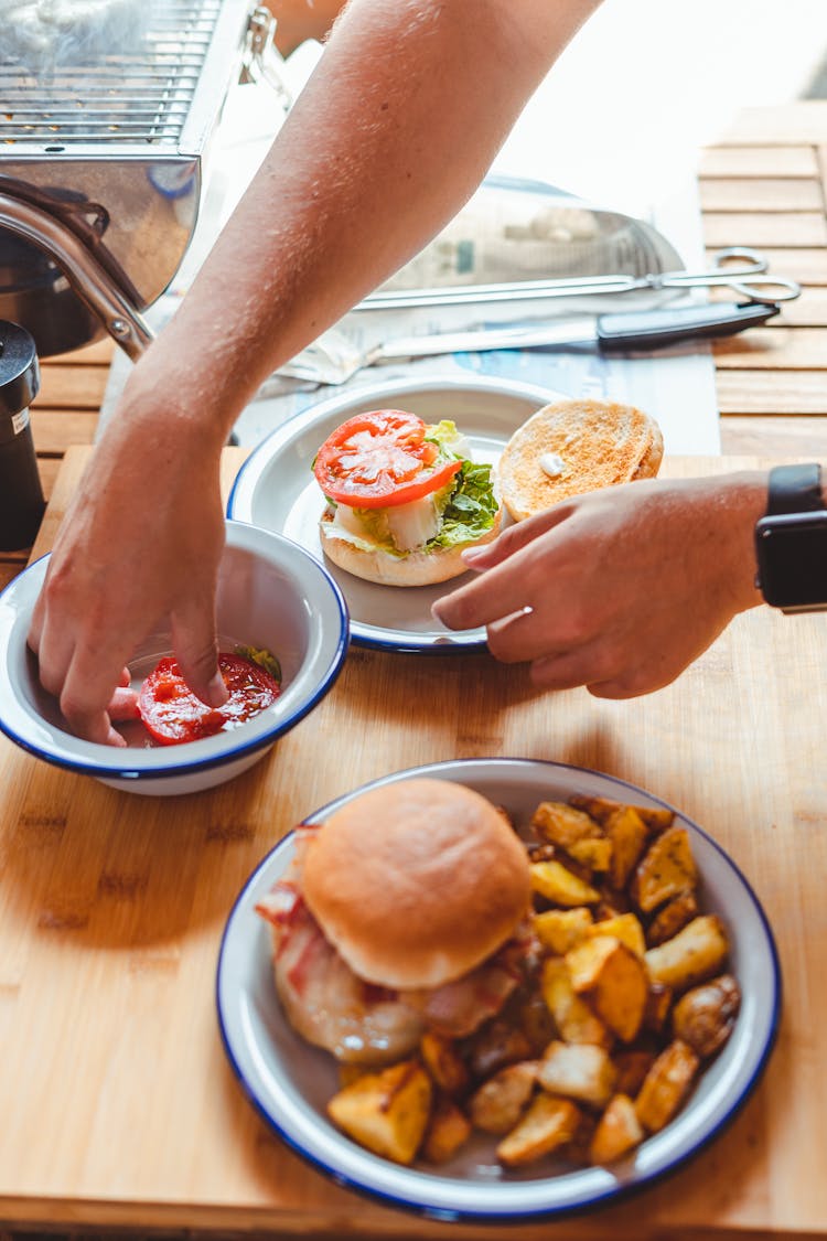 Crop Man Making Burger With Tomato