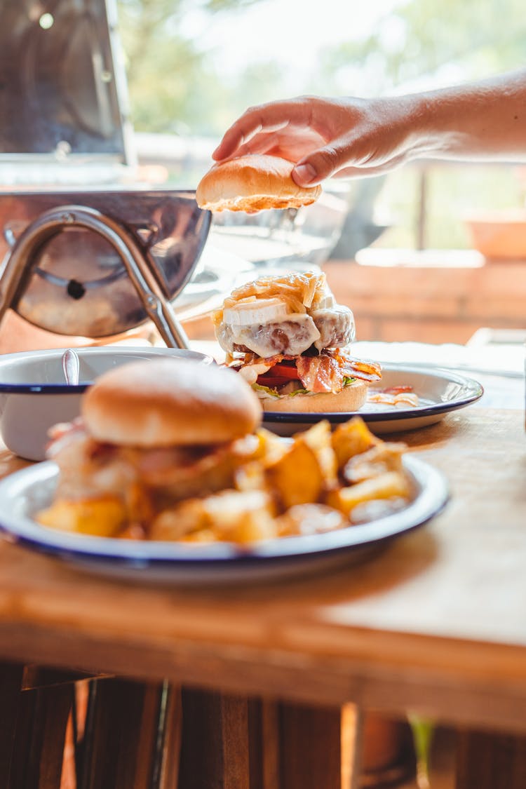 Crop Man Putting Half Of Bun On Burger