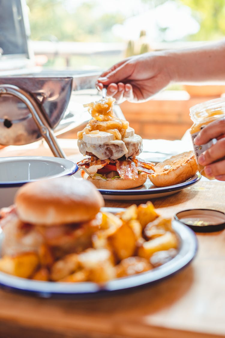 Crop Man Making Burger With Sauce