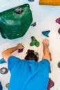 Unrecognizable climber ascending artificial rock