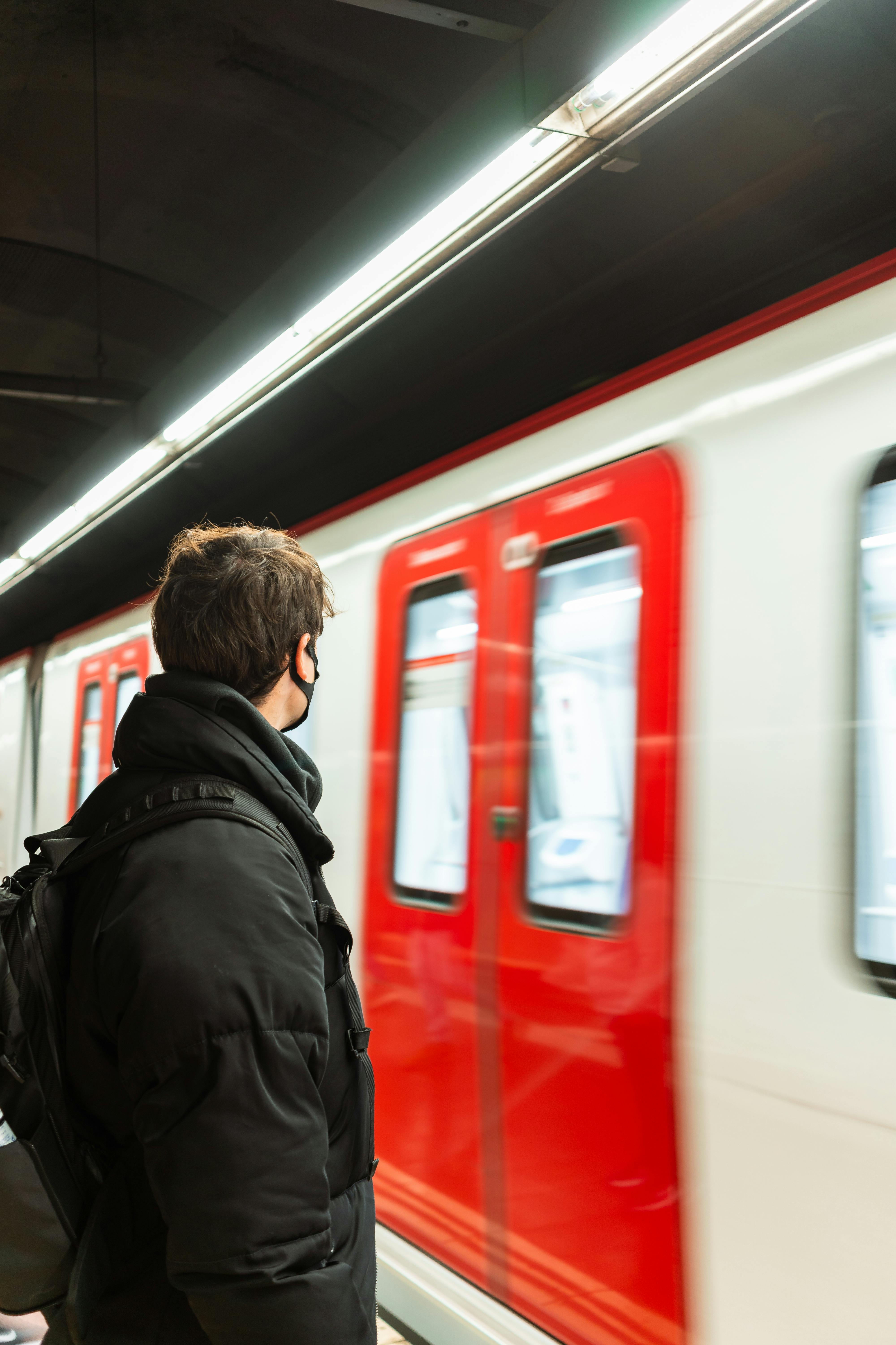 anonymous man standing on subway station near train