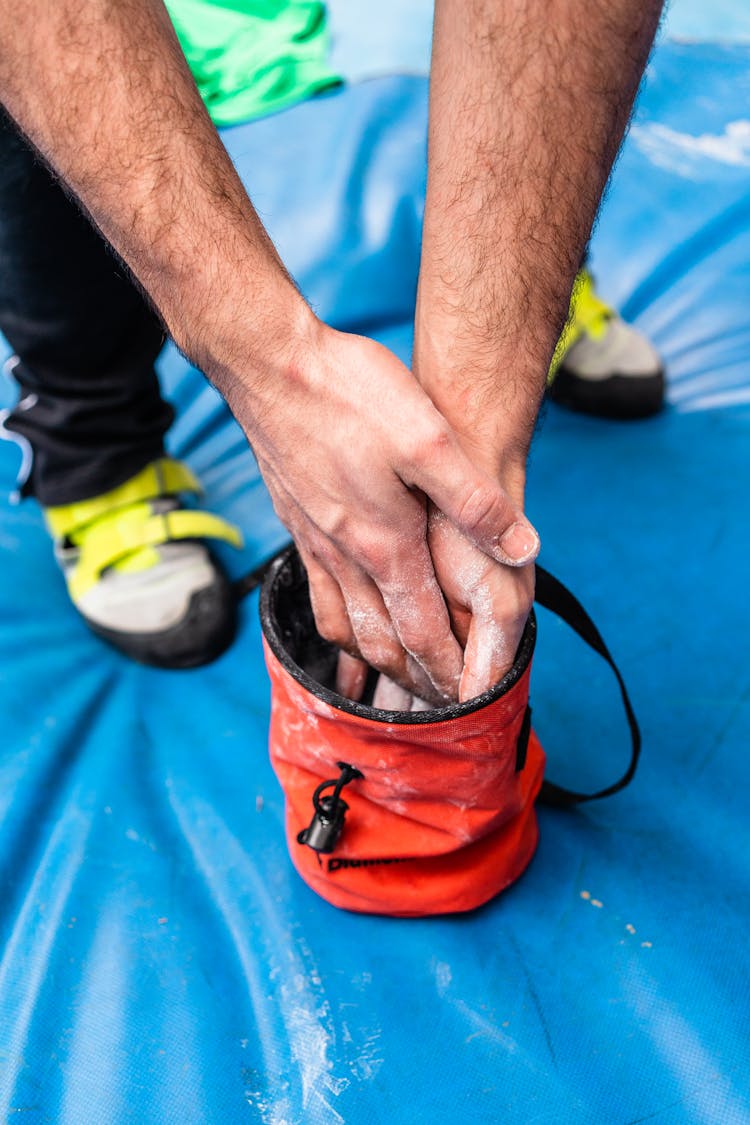 Crop Alpinist Applying Chalk On Hands