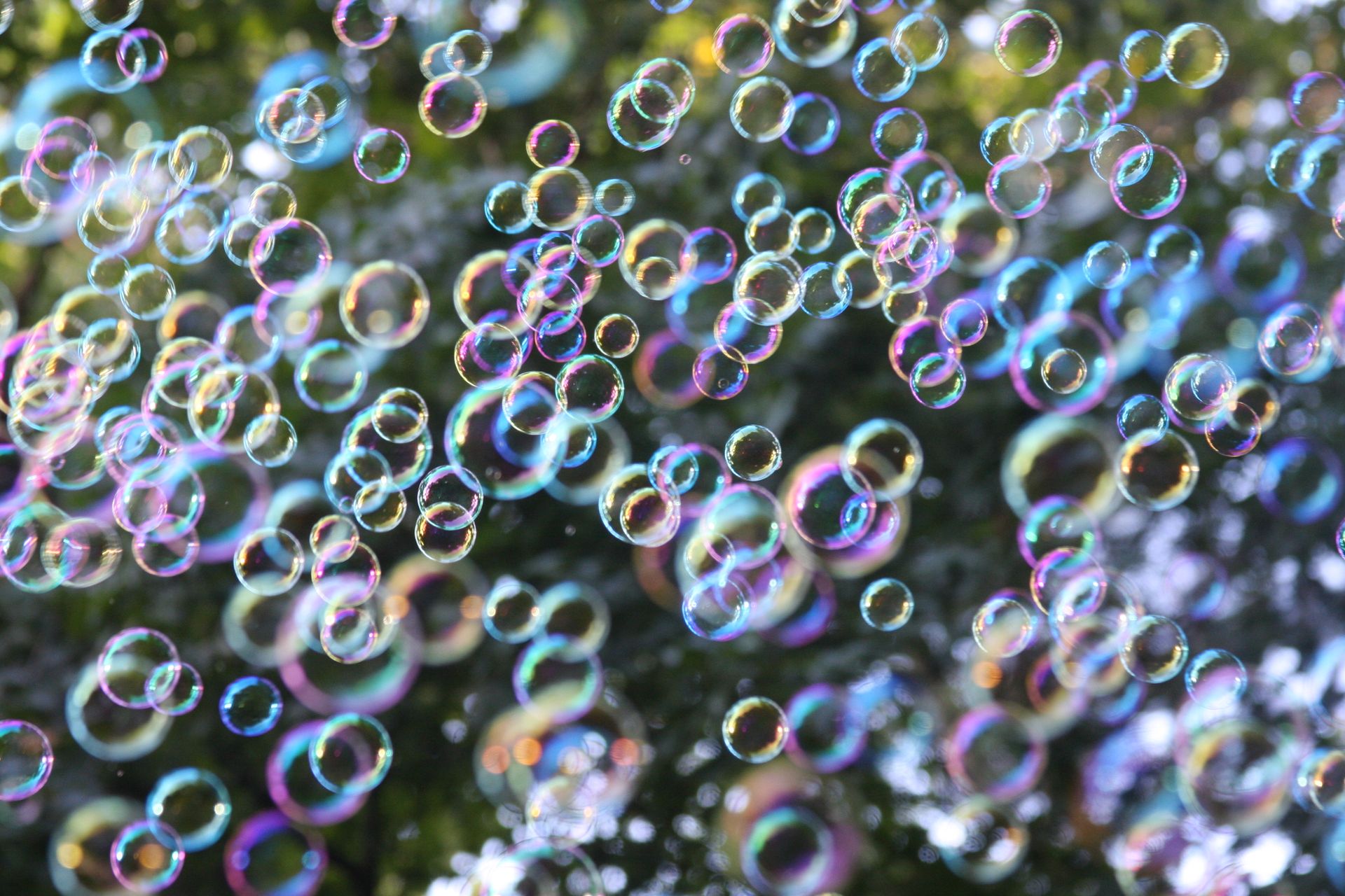 Vibrant soap bubbles floating against a blurred outdoor background, capturing joy and playfulness.