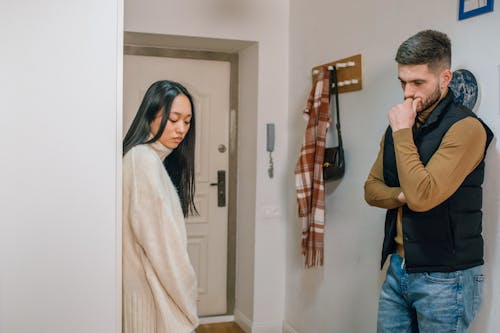 An Upset Couple Standing Near the Door