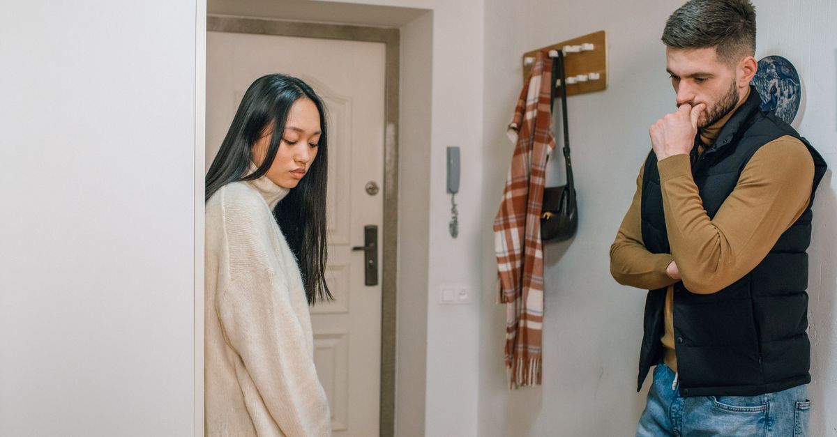 An interracial couple experiencing a tense moment inside their home.