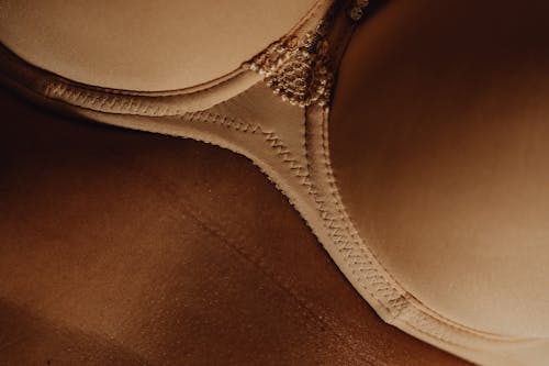 Free Brown and White Brassiere on Brown Textile Stock Photo