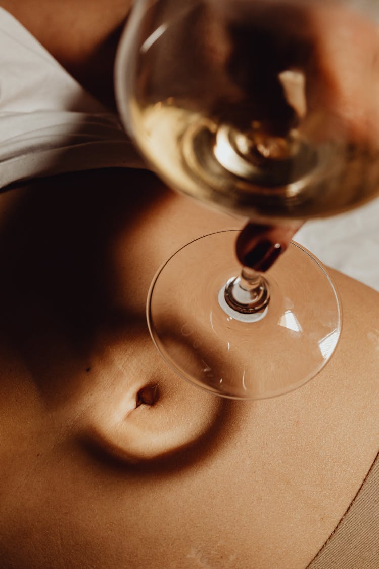 Woman Holding A Wine Glass Over Her Belly