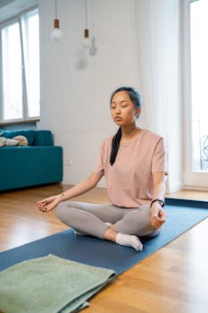 Young woman meditating indoors in a serene setting for relaxation.