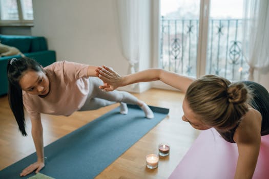 Two women practicing yoga at home, creating a relaxing and focused atmosphere.