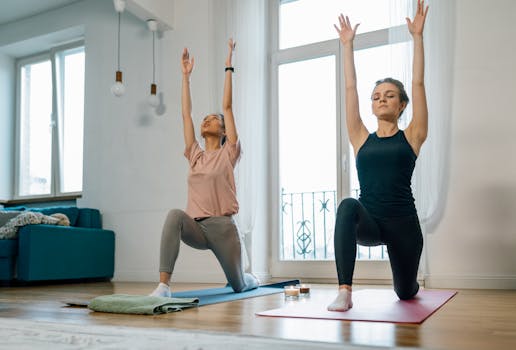 Two women in a serene setting performing yoga poses indoors, highlighting wellness and mindfulness.