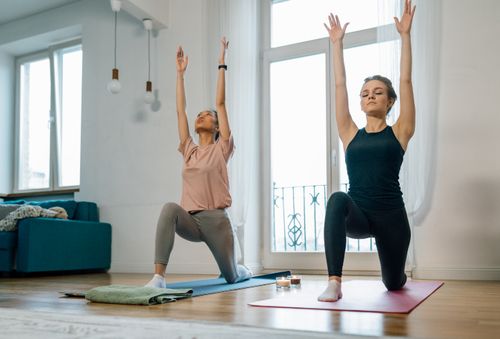 Free Two women in a serene setting performing yoga poses indoors, highlighting wellness and mindfulness. Stock Photo