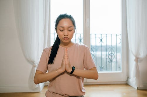 A Woman Meditating while Her Hands are Together