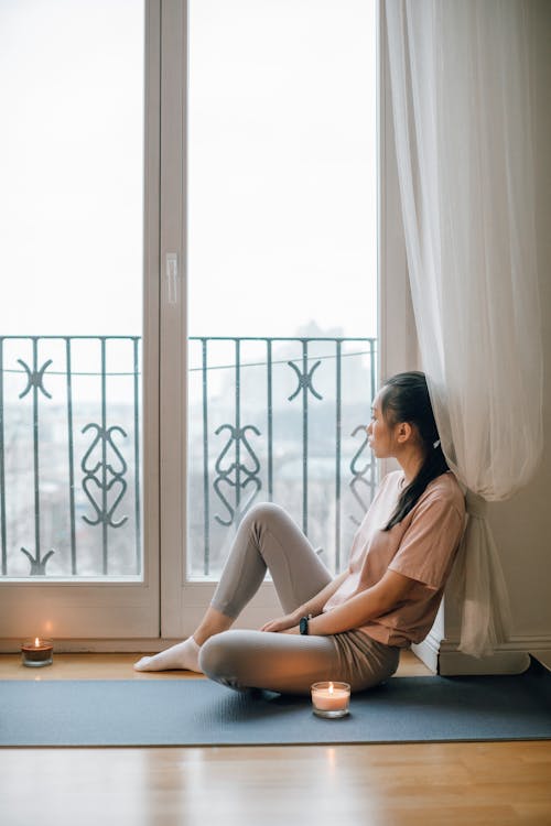 A Woman Sitting while Looking Outside a Window