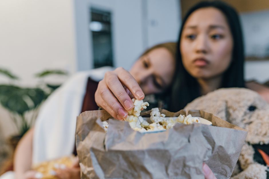 Friends enjoying popcorn and companionship during a relaxing indoor gathering.