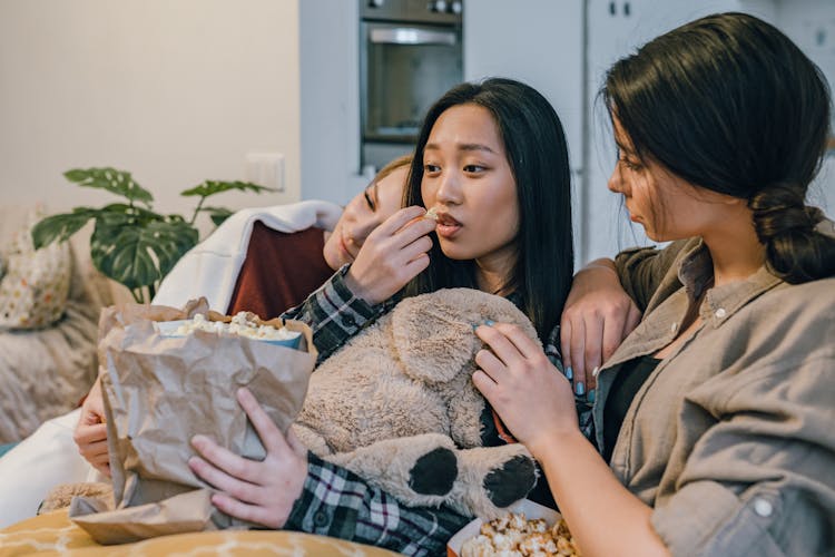 Women Sitting Together And Eating Popcorn