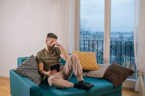 Man Sitting n Couch near Glass Window