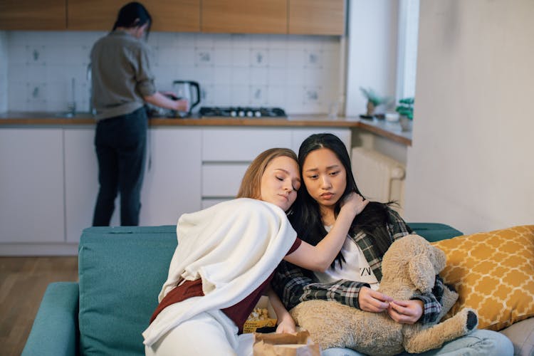 Two Sad Women Sitting On Blue Couch