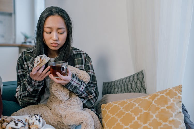 Sad Woman Holding A Cup Of Tea And Bread