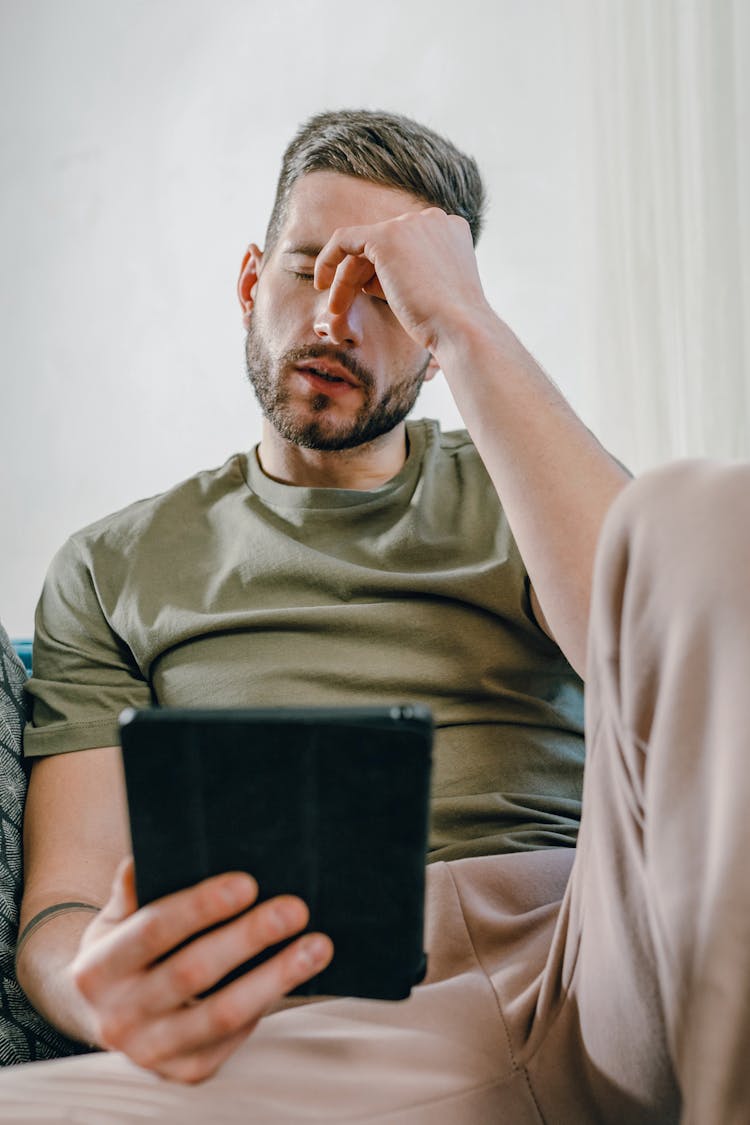 Photo Of A Stressed Man Holding A Tablet